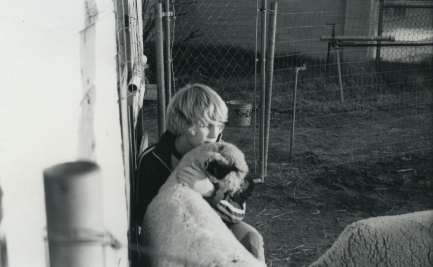 John Putz sits with a sheep.