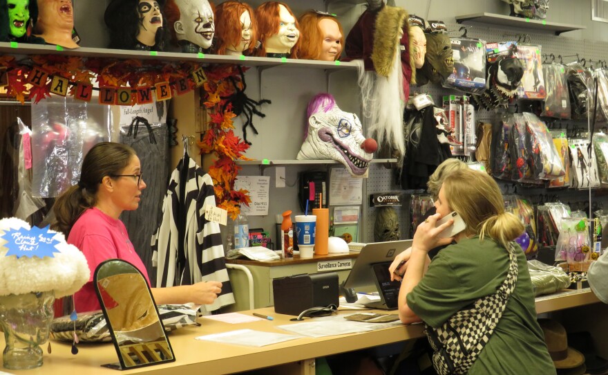 Cashier at Starline Costumes checks out customers on Halloween day.