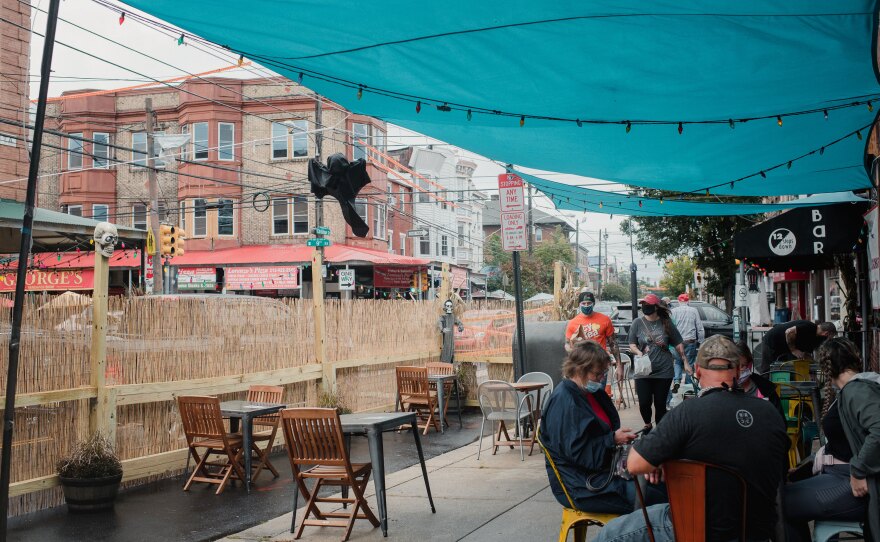 At the 12 Steps Down Bar, two parking spaces are blocked off with wooden barriers, tall reeds and strings of lights.