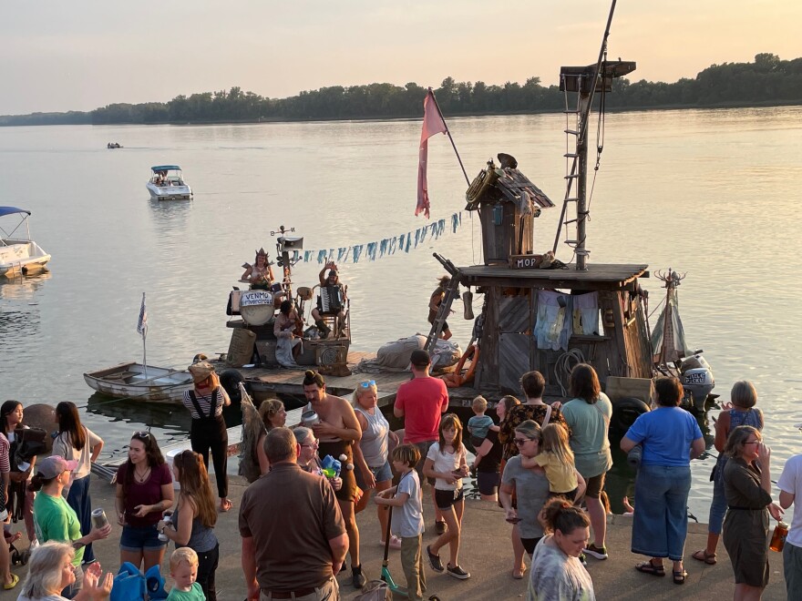 A three-piece band (left) plays at the conclusion of a FLOTSAM! performance on the Evansville riverfront