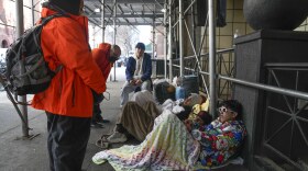 Recent immigrants to the United States lie on the sidewalk with their belongings as they talk to city officials in front of the Watson Hotel in New York, Monday, Jan. 30, 2023. The immigrants, mostly from Venezuela and other Latin American countries, had been living in the hotel until recently, when they were told to leave the temporary shelter.