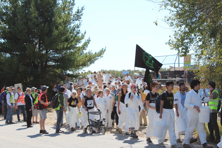 Activists carried signs and banners, including for groups like Extinction Rebellion, as they marched outside Merrimack Station.