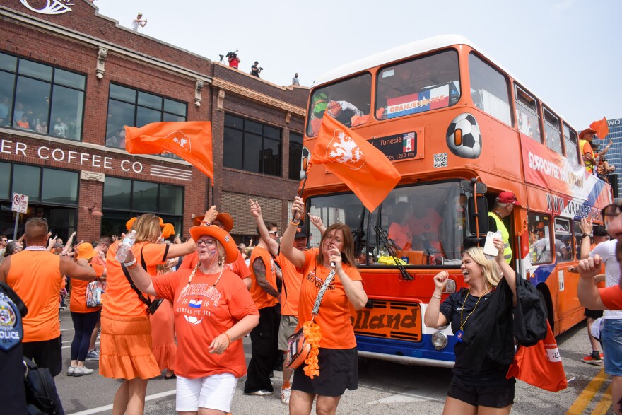 Fans are jubilant in front of the Oranje Fanwalk's double-decker bus on Thursday. The Netherlands will play Tunisia on Thursday night at Arrowhead Stadium.