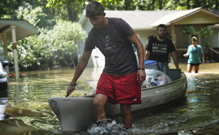 Residents transport items from their flooded homes by kayak in Indianapolis, Sunday, Aug. 16, 2026.