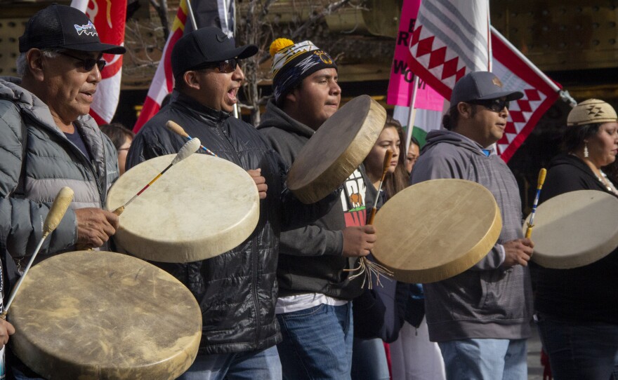 A group of men playing the drums while marching.