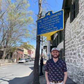 Kingston historian Taylor Bruck stands under the state placard honoring the intersection — a surprisingly popular local attraction.