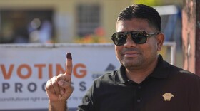FILE - A man holds up his ink-stained finger