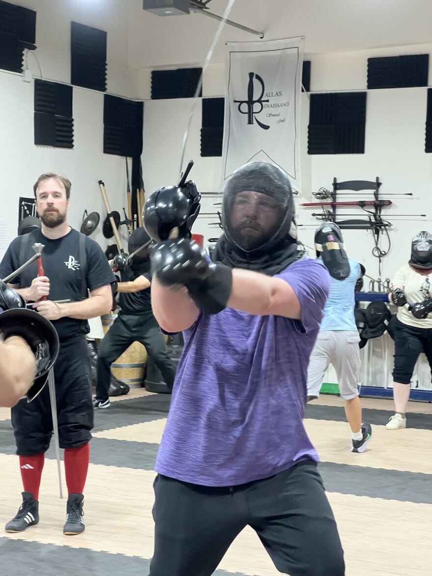 Will Phillips ( left), principal instructor at the Dallas Renaissance Sword Guild, looks on as a student practices sword technique.