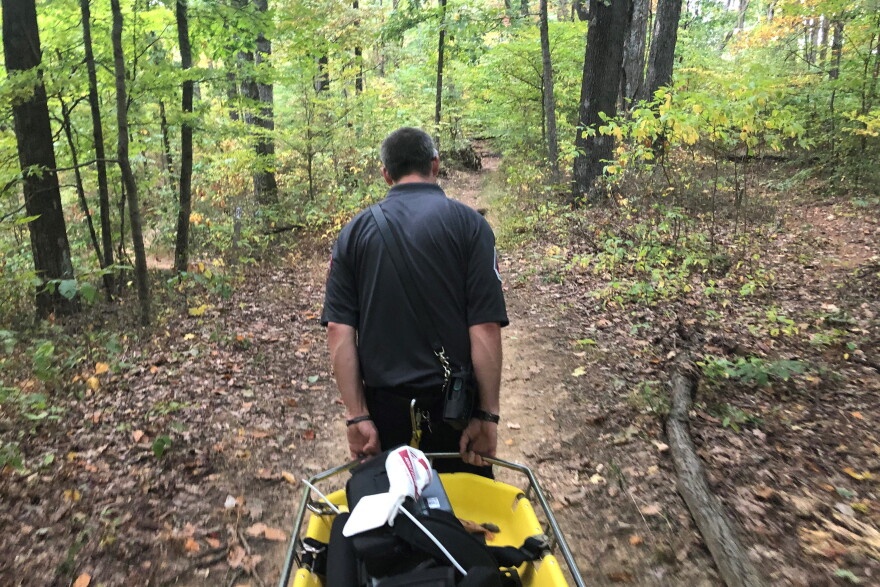 An emergency responder carries a stretcher into the Charles Deam Wilderness Area, Sept. 30