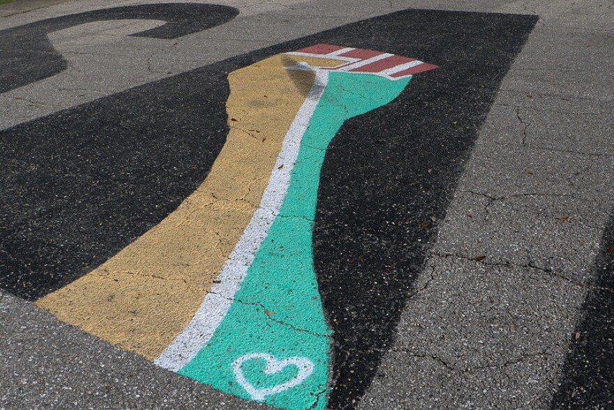  Black Lives Matter fist on the 'A' of the word 'Salute' painted in the parking lot of the Law Offices of Anabelle Dias. 