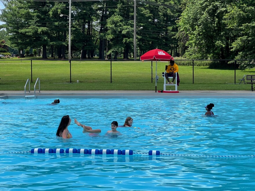 People swim in the Northside Pool in Youngstown as a lifeguard looks on.