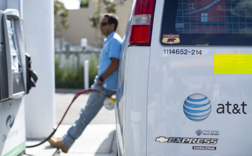 Prices for both gasoline and natural gas have fallen this year. An AT&T employee fills up his company van in San Diego last month.