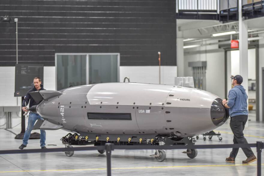 A pair of Anduril employees haul a Dive-LD autonomous submarine across the defense contractor’s Quonset Point factory floor ahead of Defense Secretary Pete Hegseth’s arrival on Feb. 9, 2026.