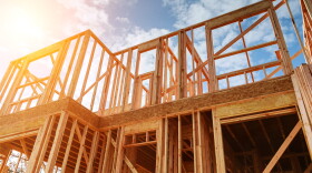 New residential construction home framing against a blue sky. Roofing construction. Wooden construction