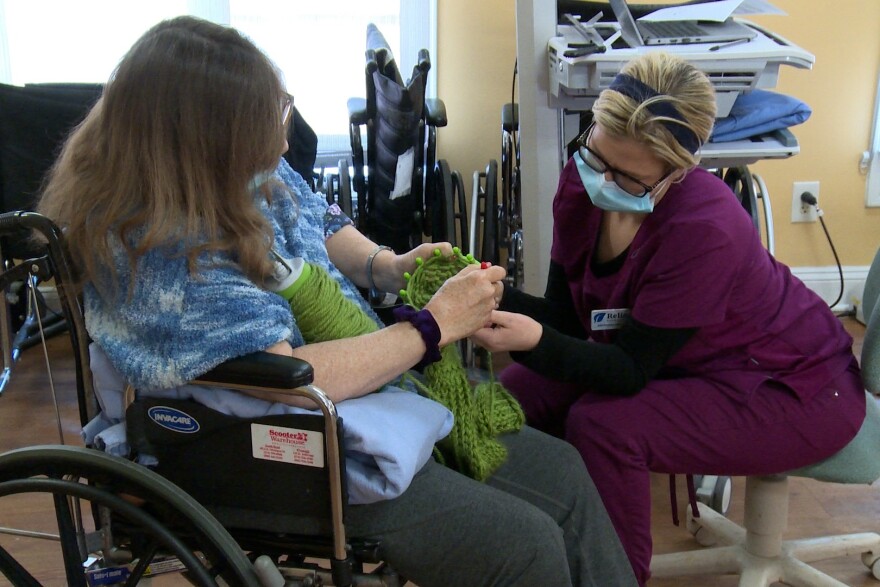  A nursing home worker at Majestic Care in South Bend, Indiana, helps a resident with an exercise.