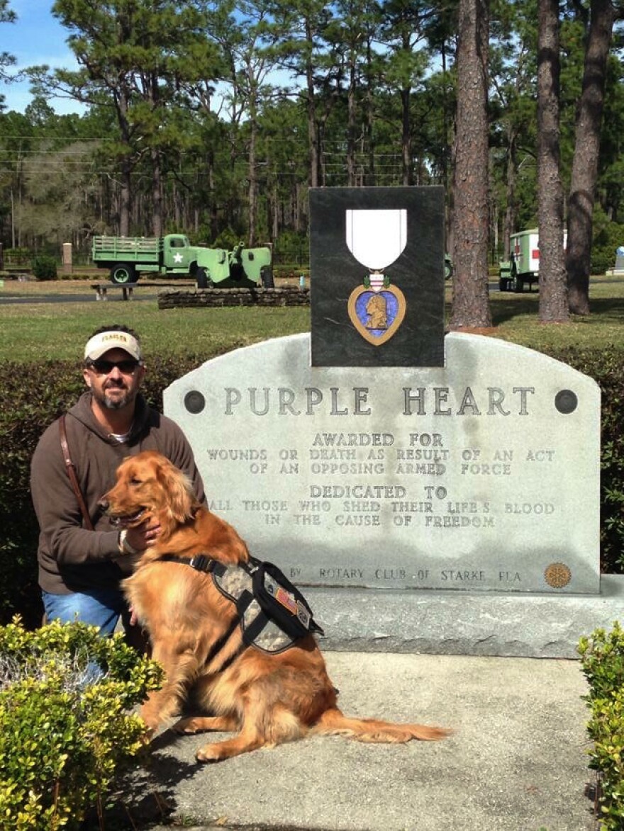 Retired Army Sgt. Kevin Crowell sits with Bella, his psychiatric service dog.