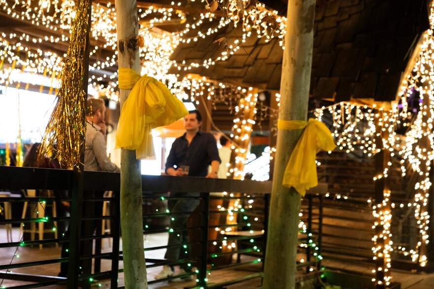 Yellow ribbon hangs from trees outside Buford's to honor the victims of a shooting early Sunday.