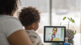 Mother on a remote medical call with a doctor about her sick child (via iStock)