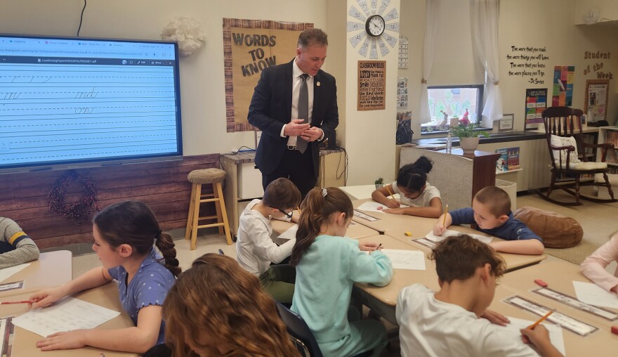 State Rep. Dane Watro watches students practice their cursive handwriting at Valley Elementary/Middle School.