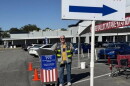 A Leon poll worker smiles and shows thumbs up 