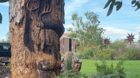 A deer with antlers is carved into a tree stump
