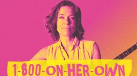 Ani Difranco holding a string instrument with the text 1-800-on-her-own in front of her