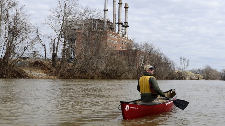 Mark Bishopric, a managing partner of Three Rivers Outfitters, paddles past the Duke Energy Dan River Steam Station in February 2014. Tens of thousands of tons of coal ash leaked into the river from a retaining pond below the steam station.