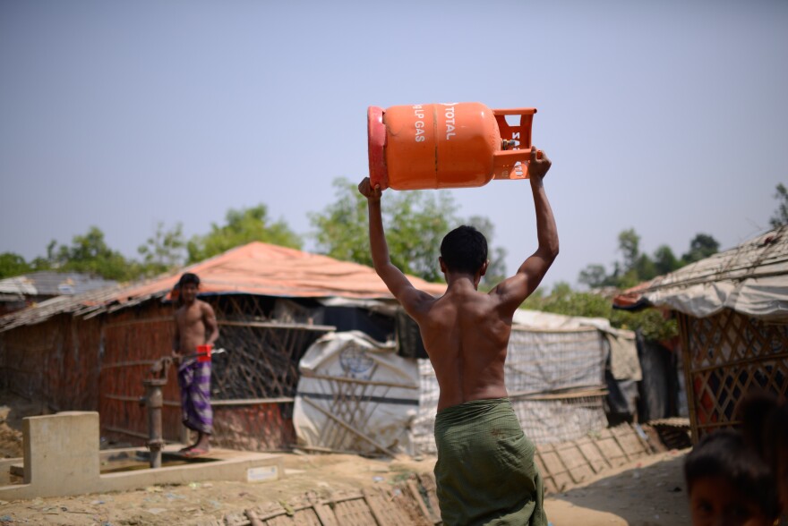 A Rohingya refugee carries a gas cylinder back to his shelter in the Balukali refugee camp. The U.N. refugee agency, along with other aid organizations, has launched a program to replace wood cooking fires with gas stoves.
