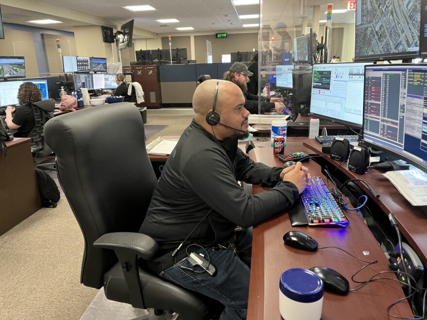 Dispatcher Damairus Reddick (center) gets settled at his desk at the Peoria Emergency Communications Center.