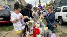 People gather at a memorial in Erie, Pa., Sunday, Oct. 11, 2026, outside the home where authorities say a gunman killed several people before killing himself on Oct. 9. 