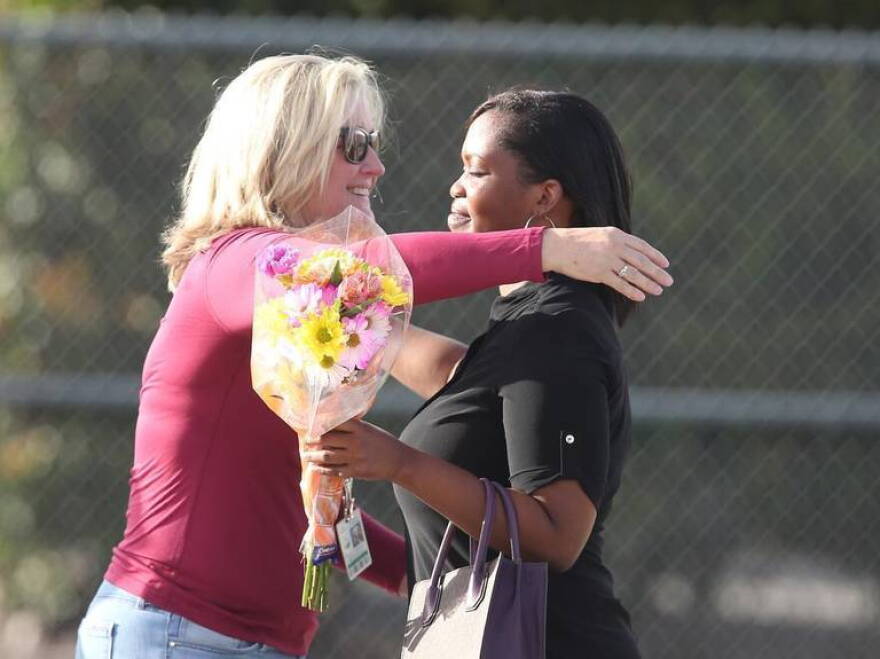 Marjory Stoneman Douglas High Assistant Principal Denise Reed hugs a school employee as she returns to campus with flowers on Feb. 23, 2018, following the mass shooting. Reed is among four school employees who are being reassigned.