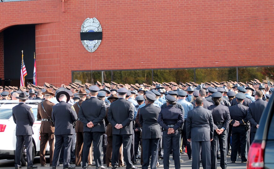 Officers stand at parade rest outside St. Louis Family Church.