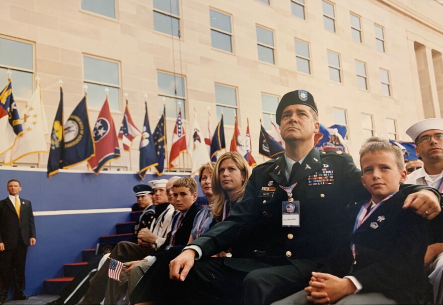 A group of military members and their families are sitting while attending a ceremony.