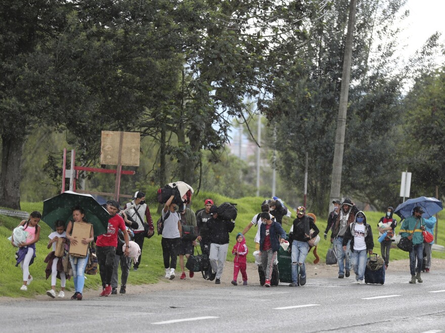 Venezuelan migrants in Colombia walk toward the border amid the coronavirus lockdown. Colombian officials say 12,000 Venezuelans have taken buses back to their home country since Colombia imposed restrictions to stop the outbreak.