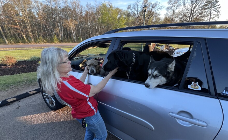 Tammy Southmayd pets her three dogs waiting inside her vehicle in the parking lot of the Crosslake Community Center after evacuating her home located in the vicinity of the Flanders Fire on May 16, 2026, in Crosslake. County and American Red Cross officials were preparing the center to accommodate overnight guests and dogs.