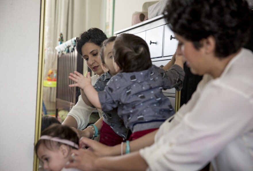 Leah Bahrencu is photographed with twins Lukas and Sorana, both 11 months, at their home in Austin, Texas.