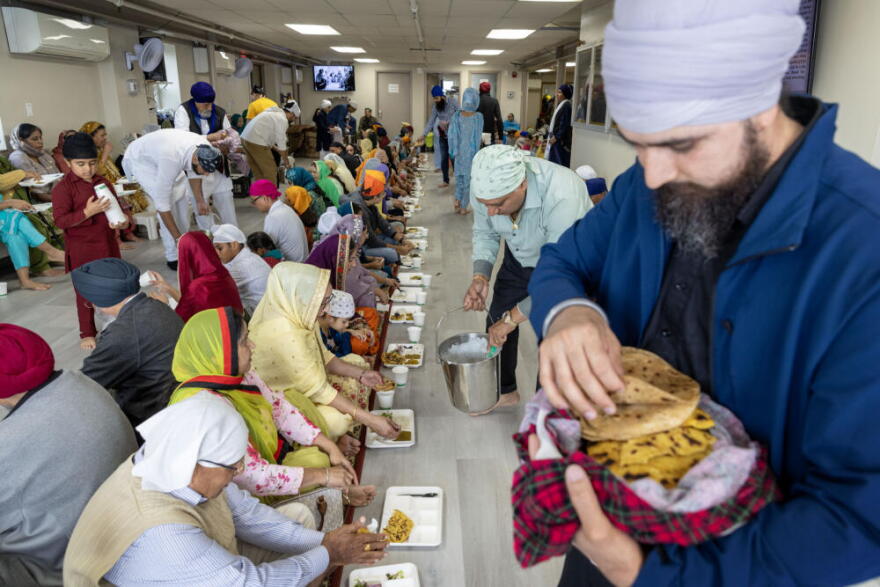 Congregants and visitors have lunch at the langar of the Gurdwara Guru Nanak Darbar in Medford, Mass. (Robin Lubbock/WBUR)