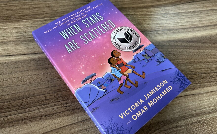 A book cover with purple and pink colors on a wooden desk