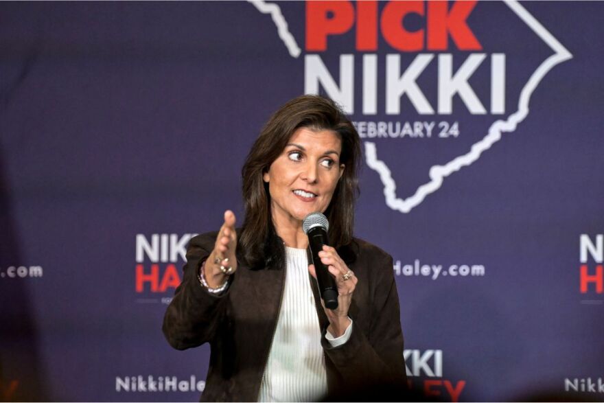 a woman speaks into a microphone on stage