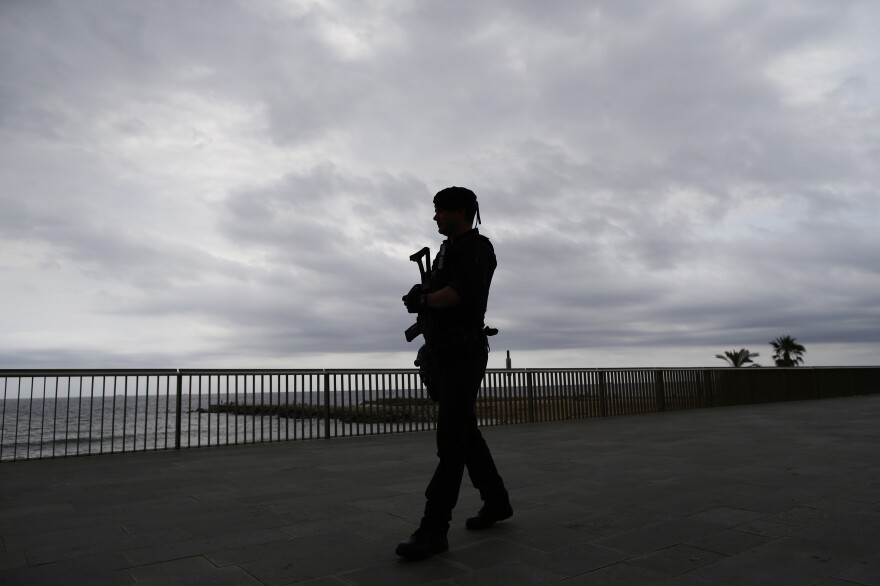 A Catalunya regional police officer patrols the Barceloneta beach front in Barcelona, Spain, Saturday, Aug. 19, 2017. Police on Friday shot and killed five people carrying bomb belts who were connected to the Barcelona van attack, as the manhunt intensified for the perpetrators of Europe's latest rampage claimed by the Islamic State group. (AP Photo/Manu Fernandez)