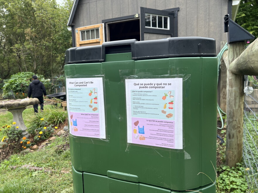 A green compost bin is labeled with instructions in English and Spanish.