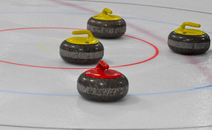 Curling stones sit on a target. They are made from a specific type of granite from Scotland.