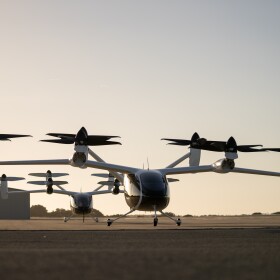 Two electric air taxi aircraft parked on a runway.