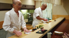 Jiro Ono (left) owns and runs a celebrated sushi restaurant in a Tokyo basement. His oldest son, Yoshikazu, waits to take over the world-famous family business.