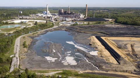 The Richmond city skyline can be seen on the horizon behind the coal ash ponds along the James River near Dominion Energy's Chesterfield Power Station in Chester, Va., Tuesday, May 1, 2018. Dominion wants to build a new, natural gas-fueled power plant on the site.