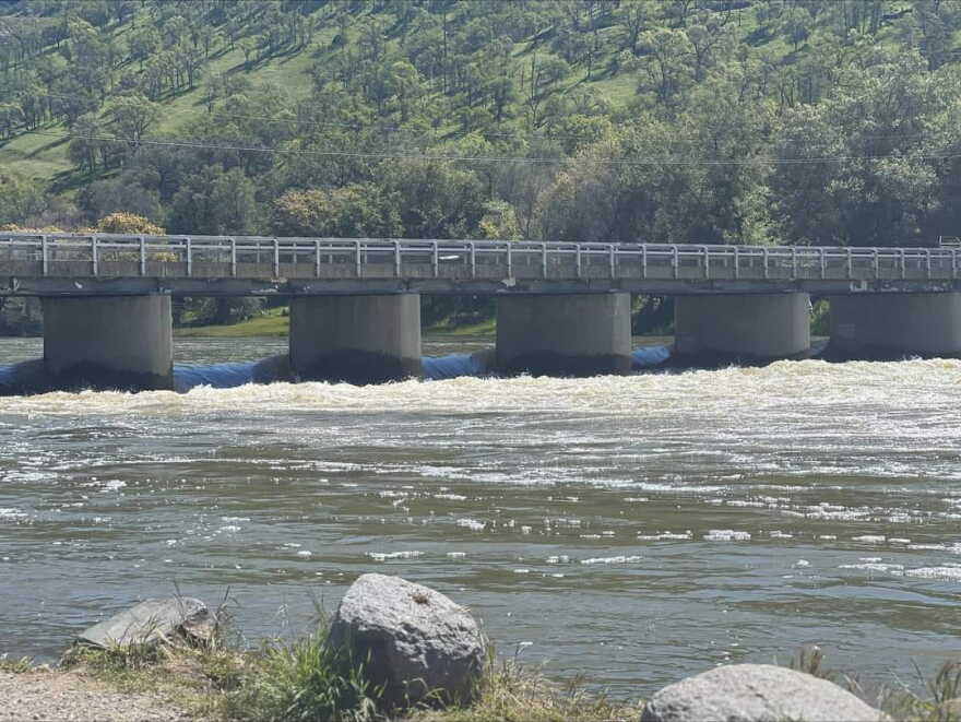 Water rushes under a bridge as California's snowmelt ramps up during high temperatures.