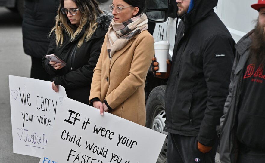 Protesters hold signs outside the Wilkes-Barre Police Department on Wednesday.