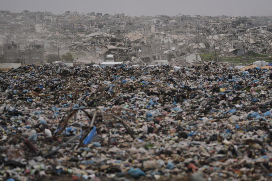 Destruction left by the Israeli air and ground offensives stand behind a landfill in Khan Younis, Gaza, Thursday, Jan. 22, 2026. (Jehad Alshrafi/AP)