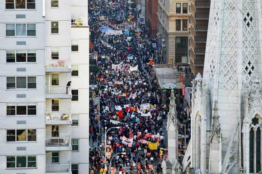 Protestors marching down a street in New York, as seen from above.
