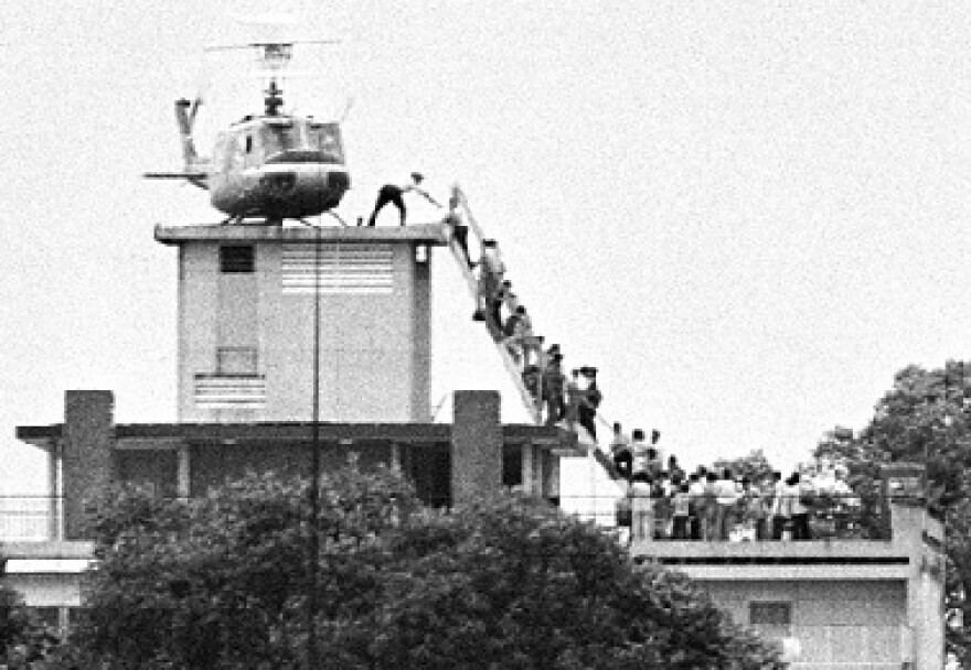 A member of the CIA helps evacuees up a ladder onto an Air America helicopter on the roof of a hotel half a mile from the Embassy, April 29, 1975, shortly before Saigon fell to advancing North Vietnamese troops. Dutch photojournalist Hubert van Es took the iconic photo from the offices of the United Press International.